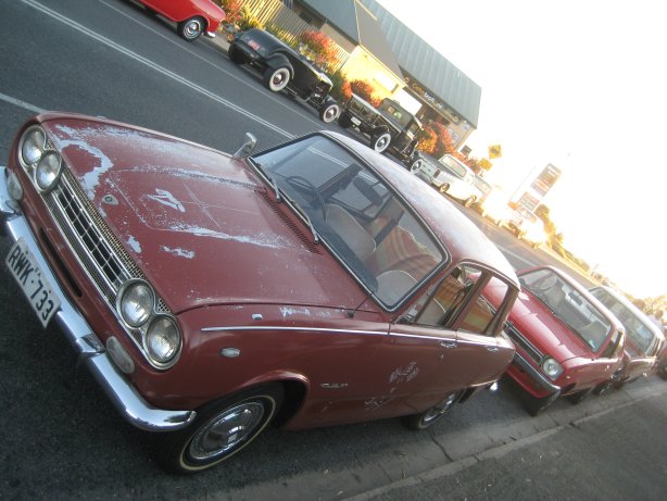 16 - Isuzu Bellett ratter, Holden Gemini coupe and rods in background.JPG